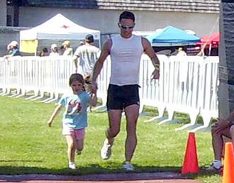 dad young daughter finishing triathlon