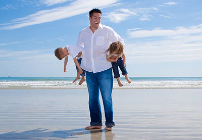 dad-carrying-2-preschool-kids-beach-laughing
