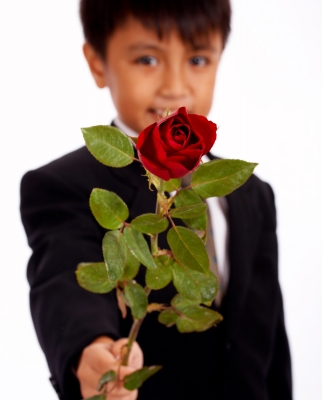 school-age boy presenting rose