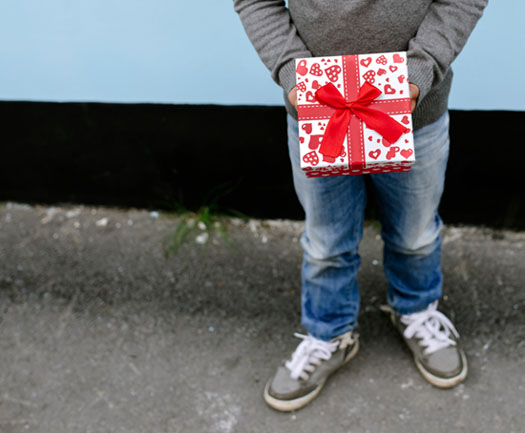 child holding Christmas gift waist down