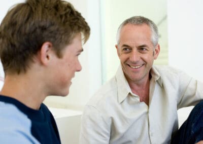 dad teen son talking smiling